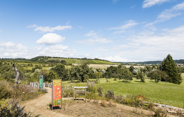 Blick auf den Spielplatz Wildkatzenwelt am Naturparkzentrum. Aufnahme aus der Ferne mit Blick in die Umgebung mit Wiesen und im Hintergrund Weinbergen. | © Tourismus Marketing GmbH Baden-Württemberg