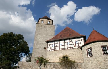 Das Schloss hat Fachwerk außen und einen hohen Turm | © Touristikgemeinschaft Hohenlohe e. V. | Marion Schlund