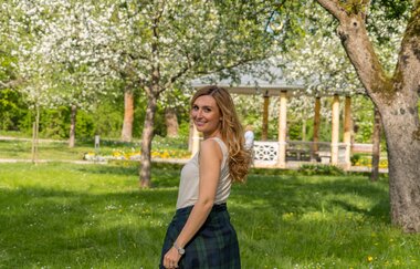 Eine junge Frau blickt  beim Laufen zurück in die Kamera. Sie läuft in einem Park. | © Stadt Bad Mergentheim