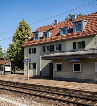 Seitliche Ansicht vom Bahnhof Fichtenberg und Zuggleise.