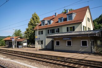 Seitliche Ansicht vom Bahnhof Fichtenberg und Zuggleise.