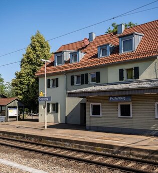 Seitliche Ansicht vom Bahnhof Fichtenberg und Zuggleise.