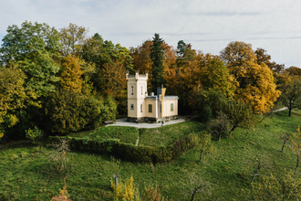 Eine kleine Villa mit Turm steht auf einem grünen Hügel, umgeben von herbstlich bunten Bäumen. | © Stadtverwaltung Crailsheim