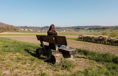 Eine Frau sitzt auf einer Bank und blickt in die Ferne | © Stadtverwaltung Crailsheim