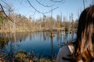 Eine Frau blickt auf einen blauen Dolinenseen | © Stadtverwaltung Crailsheim