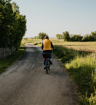 Eine Radfahrerin fährt entlang von Feldern | © Stadtverwaltung Crailsheim
