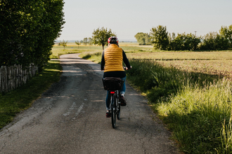 Eine Radfahrerin fährt entlang von Feldern | © Stadtverwaltung Crailsheim