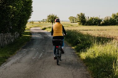 Eine Radfahrerin fährt entlang von Feldern | © Stadtverwaltung Crailsheim