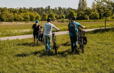 Vier Fahrradfahrer laufen über eine Wiese | © Stadtverwaltung Crailsheim