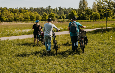 Vier Fahrradfahrer laufen über eine Wiese | © Stadtverwaltung Crailsheim