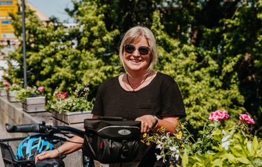 Eine Fahrradfahrerin lehnt mit ihrem Rad an der Jagstbrücke