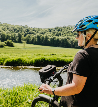 Eine Radfahrerin steht mit ihrem Fahrrad am Jagstufer | © Stadtverwaltung Crailsheim