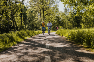 Vier Radfahrer radeln auf einem Radweg, der umgeben ist von Wiese und Bäumen | © Stadtverwaltung Crailsheim