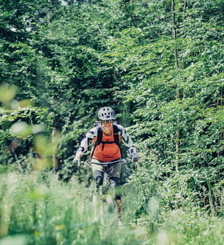 Eine Mountainbike-Fahrerin fährt auf Ihrem Bike durch den Wald | © Touristikgemeinschaft Odenwald e.V.