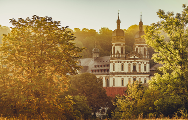 Etappe 4 - Kloster Schöntal aus der Ferne zwischen Bäumen | © Arbeitsgemeinschaft Kocher-Jagst-Radweg