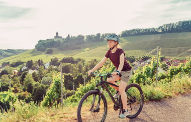 Radfahrerin am Schöllkopf in Brackenheim am Württemberger Weinradweg | © Touristikgemeinschaft HeilbronnerLand e.V.
