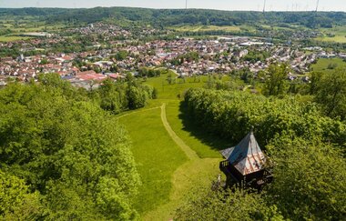 Luftaufnahme - Blick von oben auf Turmdach, Wald und Wiesen, im Tal Gaildorf, dahinter bewaldete Hügelkette der Limpurger Berge | © Stadt Gaildorf