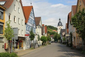 Entlang der Straße reihen sich Häuser und eine Kirche ist am Ende. | © Touristikgemeinschaft Hohenlohe e. V. | Andi Schmid