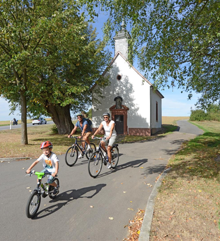 Familie auf Fahrrädern an der Josefskapelle Höpfingen | © Touristikgemeinschaft Odenwald e.V.