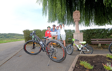 Familie mit Fahrrädern an einem Bildstock bei Höpfingen. Die Familie betrachtet eine Karte. | © Touristikgemeinschaft Odenwald e.V.