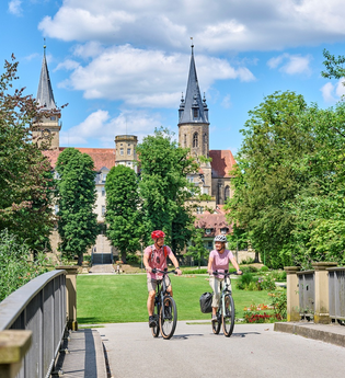 Radfahrer fahren über Brücke im Hofgarten der ehemaligen Residenzstadt Öhringen. | © Touristikgemeinschaft Hohenlohe e. V. | Florian Trykowski