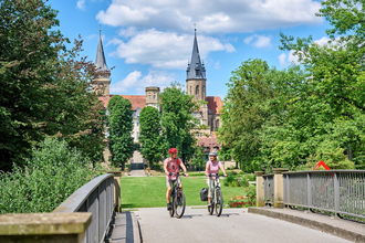 Radfahrer fahren über Brücke im Hofgarten der ehemaligen Residenzstadt Öhringen. | © Touristikgemeinschaft Hohenlohe e. V. | Florian Trykowski
