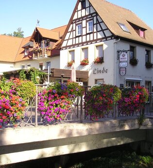 Fachwerkhaus an einer Fußgängerbrücke mit Blumenschmuck
