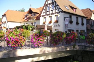 Fachwerkhaus an einer Fußgängerbrücke mit Blumenschmuck