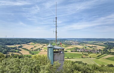 Weiter Blick über die Baumspitzen in die Hohenloher Ebene mit dem Aussichtsturm auf dem Einkorn bei Schwäbisch Hall im Vordergrund. | © Hohenlohe + Schwäbisch Hall Tourismus e. V.