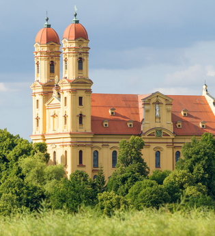 Barocke Wallfahrtskirche Schönenberg in Ellwangen , umgeben von Bäumen. | © Hohenlohe + Schwäbisch Hall Tourismus e. V.