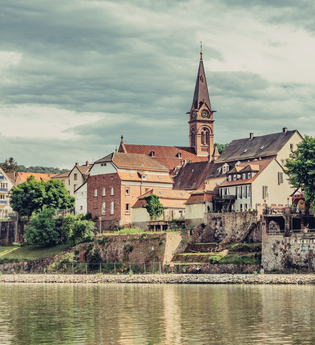 Blick auf die historische Altstadt mit Kirchturm von Neckargemünd, im Vordergrund fließt der Neckar | © Touristikgemeinschaft Odenwald e.V.