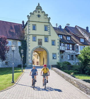Radfahrende am Würzburger Tor in Forchtenberg | © Touristikgemeinschaft Hohenlohe e. V. | Florian Trykowski