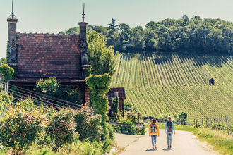 Zwei wandernde Frauen vor einem Weinbergshäuschen am Wartberg Heilbronn | © Touristikgemeinschaft HeilbronnerLand e.V.