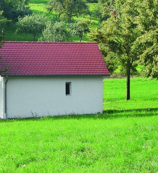 Die Kapelle liegt idyllisch inmitten einer grünen Wiese und Bäumen | © Touristikgemeinschaft Hohenlohe e. V. | Stadt Krautheim