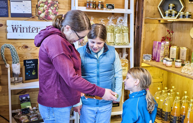 Eine Mutter erklärt ihren Kindern den Inhalt der Flasche, die sie in der Hand hat | © Touristikgemeinschaft Hohenlohe e.  V.