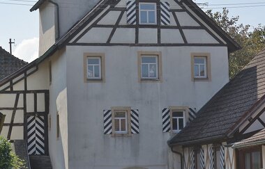 Das weiße Rundtor hat oben am Giebel Fachwerk | © Touristikgemeinschaft Hohenlohe e. V. | Andi Schmid