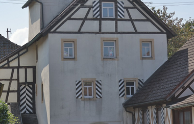 Das weiße Rundtor hat oben am Giebel Fachwerk | © Touristikgemeinschaft Hohenlohe e. V. | Andi Schmid