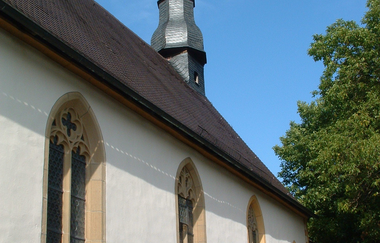 Die Kapelle hat einen langen Turm und ist von einem Baum umgeben | © Touristikgemeinschaft Hohenlohe e. V.