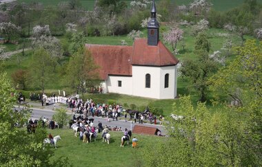 Vor der Kapelle stehen Personen und Reiter | © Touristikgemeinschaft Hohenlohe e. V.