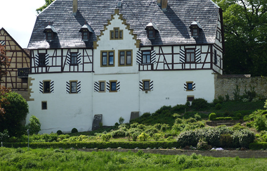 Das ehemalige Schloss hat einen Fachwergiebel und ist weiß gestrichen | © Touristikgemeinschaft Hohenlohe e. V.