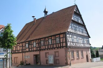Rötliches Fachwerkgebäude an einer Straße | © Stadt Sinsheim