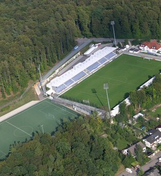 Luftbild Fußballstadion mit mehreren Rasenplätzen am Waldrand