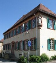 Historisches Gebäude mit weißen Sprossenfenstern und grünen Fensterläden an einem klaren Sommertag | © Stadt Sinsheim