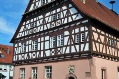 Fachwerkgebäude mit rötlichem Sockel an einem wolkenlosen Sommertag | © Stadt Sinsheim
