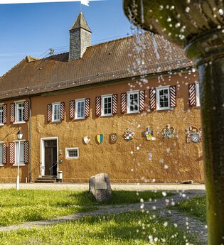 Wasserschloss Großeicholzheim mit Wiese und plätscherndem Brunnen im Vordergrund | © Touristikgemeinschaft Odenwald e.V.