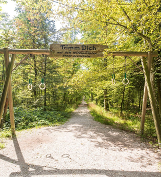 Hölzernes Sportgerät im Wald mit dem Schild ,,Trimm dich" | © Stadtverwaltung Crailsheim