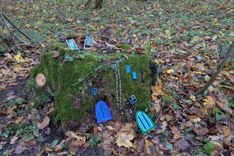 Wichtelstation Haus mit Wichteltüren an einem bemoosten Baumstumpf im Wald | © Frau Leist