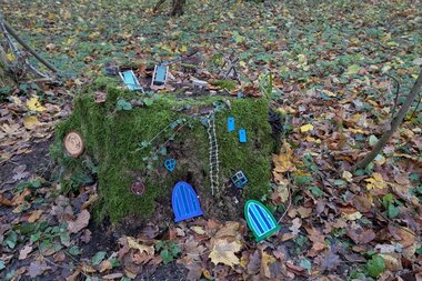 Wichtelstation Haus mit Wichteltüren an einem bemoosten Baumstumpf im Wald | © Frau Leist