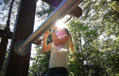 Eine Frau macht eine Übung an einem Freiluftgerät | © Touristikgemeinschaft Hohenlohe e. V. | Firma Würth