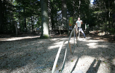 Eine Frau übt an einem Freiluftseil | © Touristikgemeinschaft Hohenlohe e. V. | Firma Würth